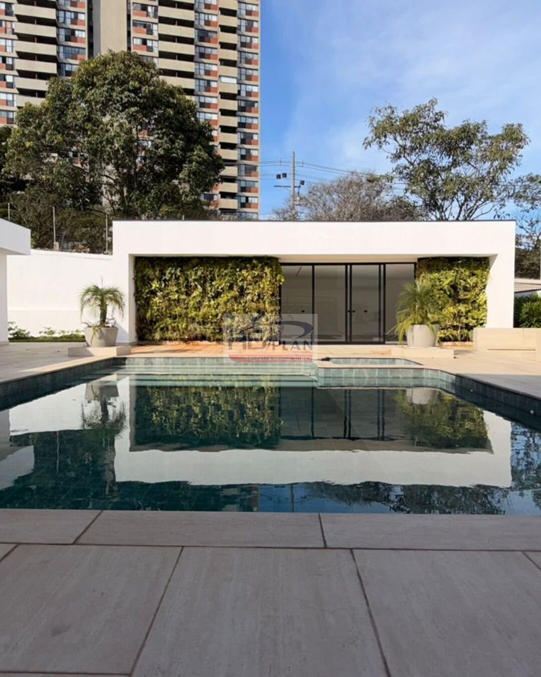 Fachada de casa de alto padrão com piscina e parede verde no Alphaville Residencial Dois, em Barueri